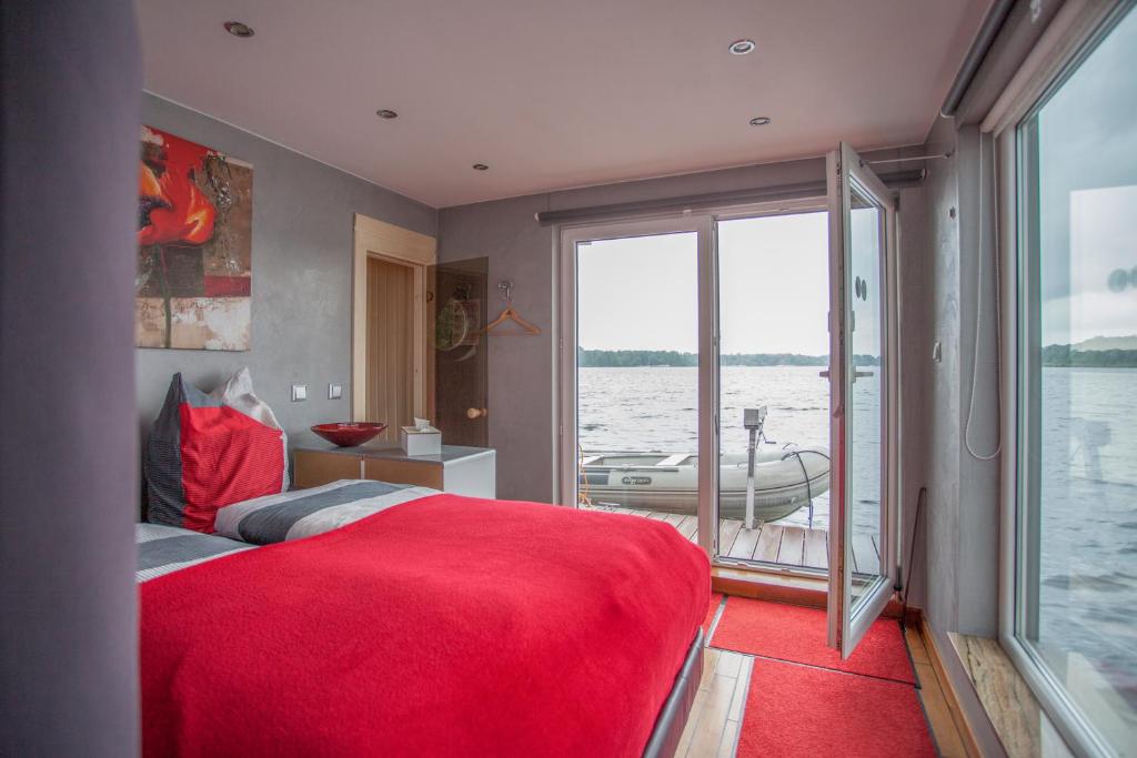 柏林豪斯布特船屋的一间卧室配有一张红色的大床,水中还有一条船