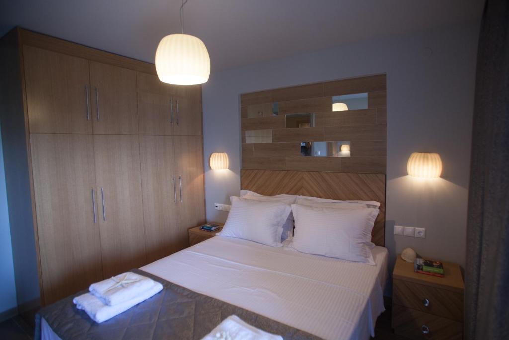 阿莫利亚尼岛Pallas Luxury Apartments的一间卧室配有带白色床单和枕头的床。