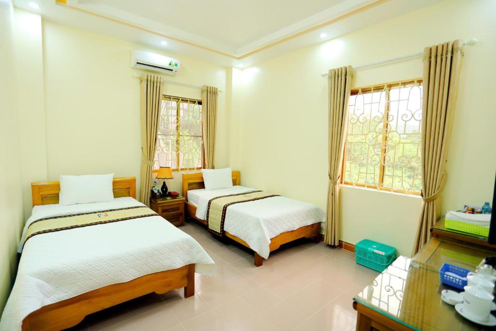 河江惠阳酒店的一间卧室设有两张床和窗户。