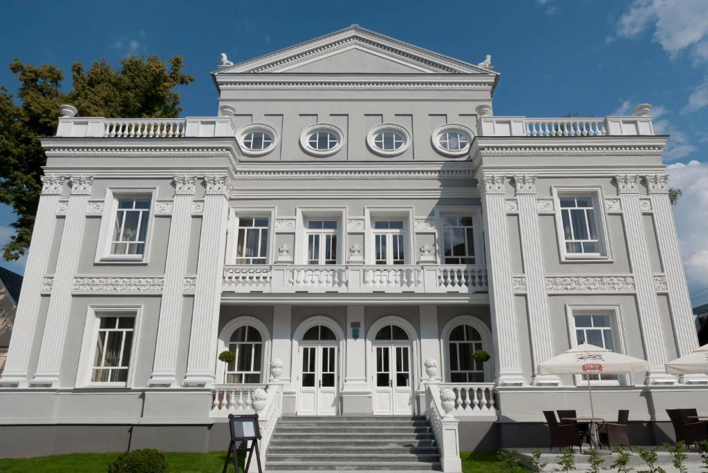 凯尔采维拉胡塔酒店的前面有楼梯的大型白色建筑