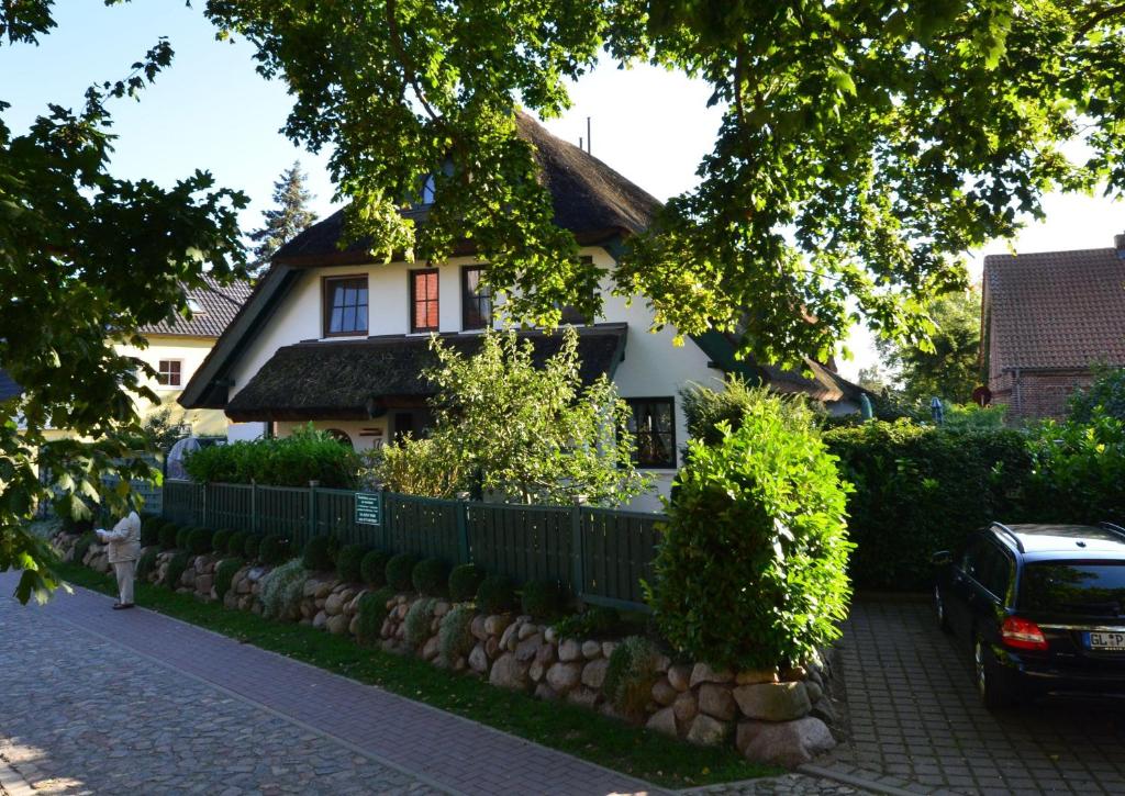 格罗斯齐克Ferienhaus-Strandflieder-in-Gross-Zicker-Halbinsel-Moenchgut的前面有围栏的房子