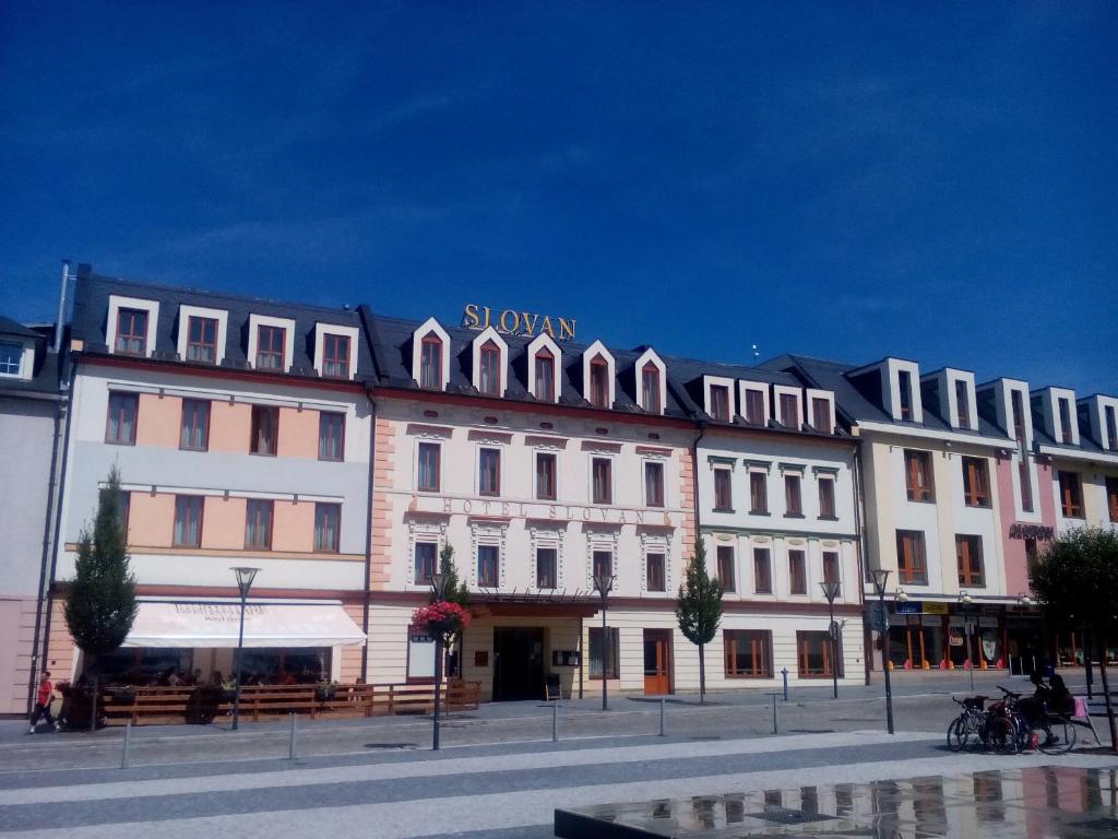 耶塞尼克Hotel Slovan的一座白色的大建筑,上面有标志