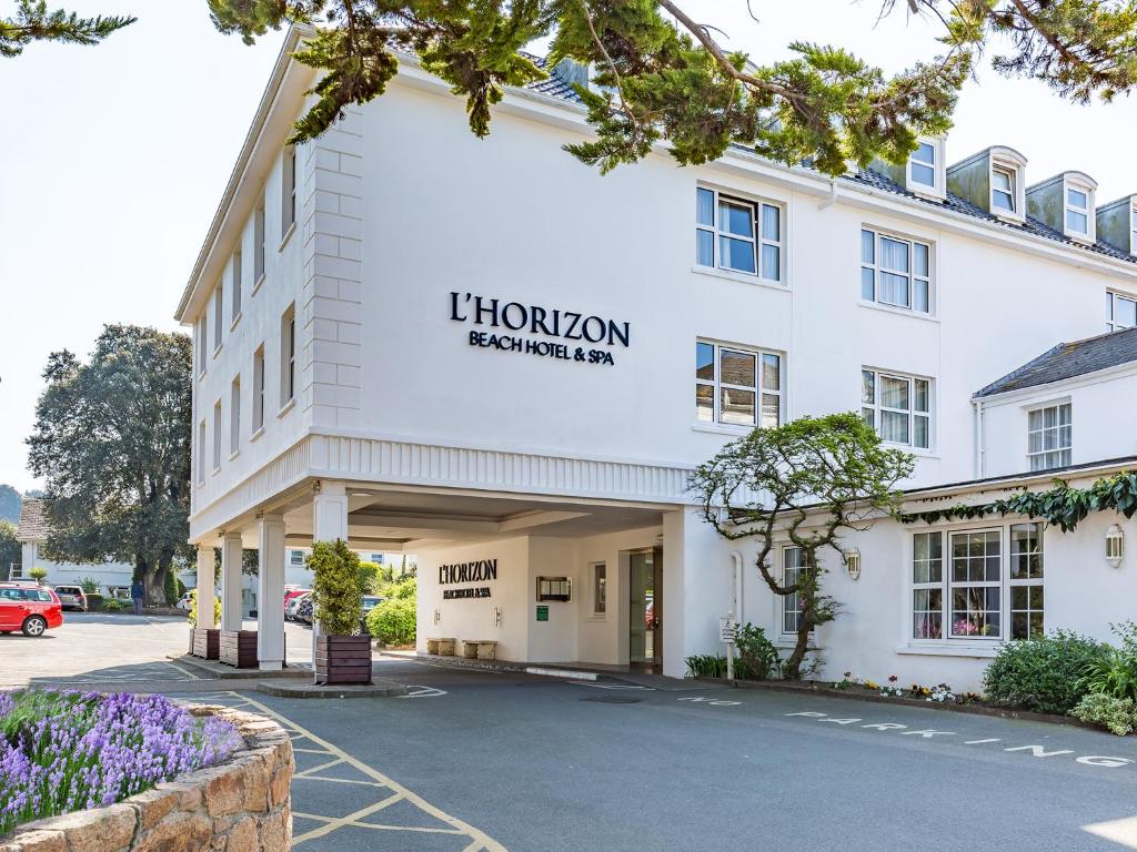 圣布雷拉德霍里佐海滨酒店及Spa的一座白色的大建筑,上面标有阅读狮子客栈的围栏