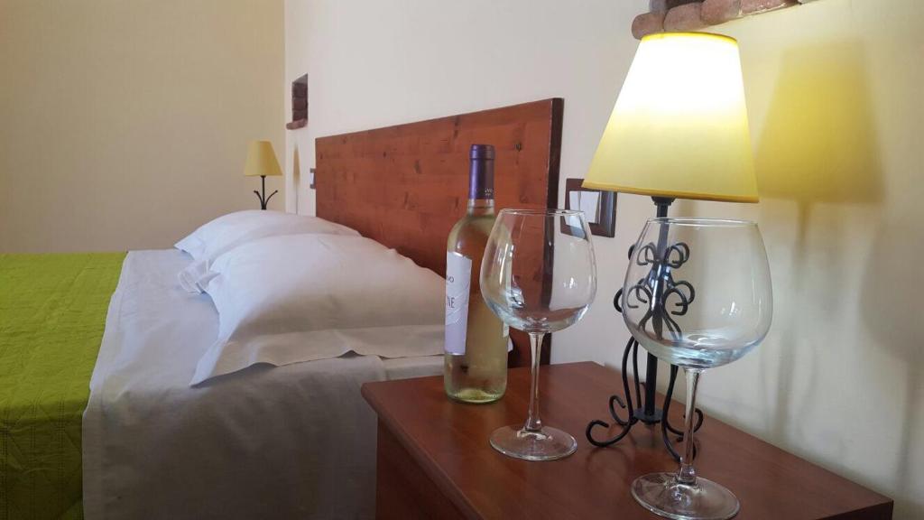瓦尔德利切Camere Con Terrazzino的一间卧室配有一张带灯和两杯酒杯的床