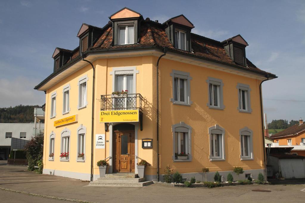 Bischofszell三同盟旅馆的一座黄色的小建筑,有屋顶