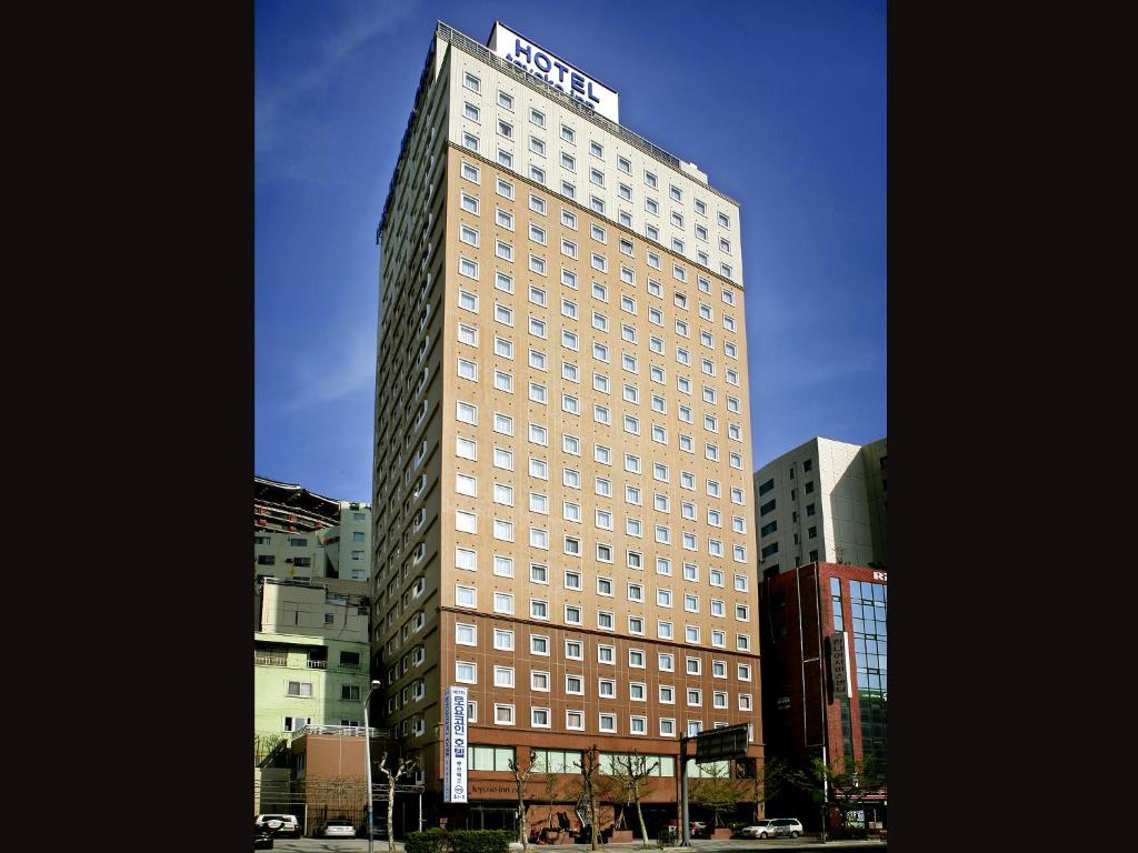 釜山Toyoko-Inn Busan Jungang Station的一座高大的建筑,上面有标志