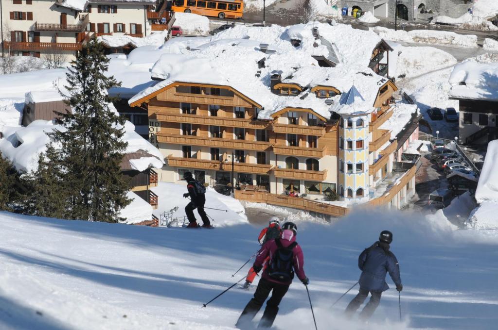 摩德纳迪-坎皮格里奥Boutique Hotel Diana的一群人沿着雪覆盖的斜坡滑雪