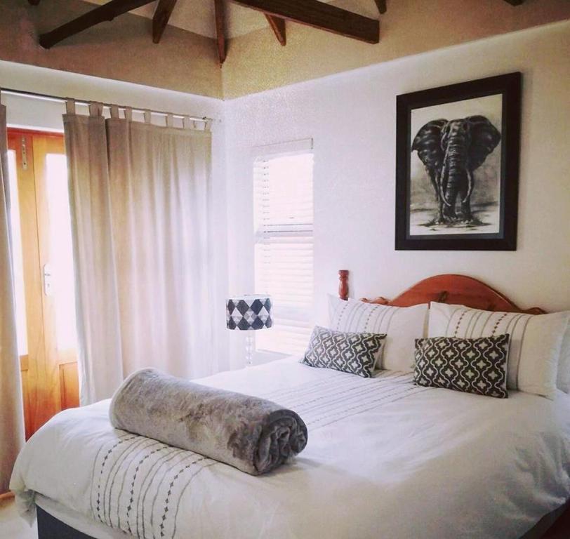 开普敦Milnerton Guesthouse的卧室配有一张白色大床,上面有大象枕头