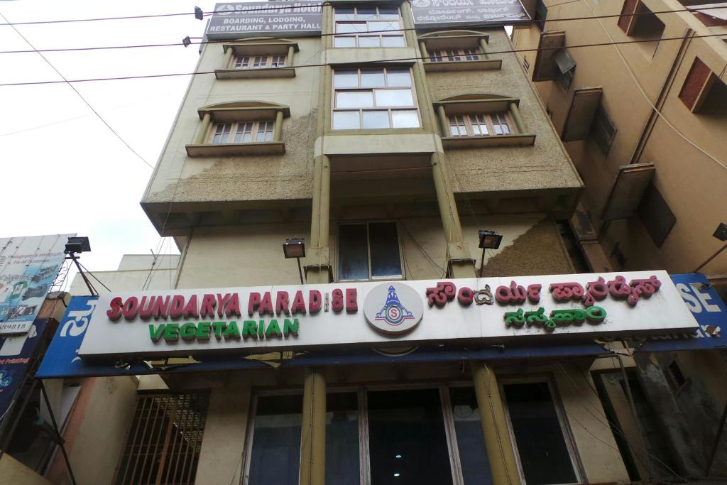 班加罗尔Soundarya Hotel的建筑的侧面有标志