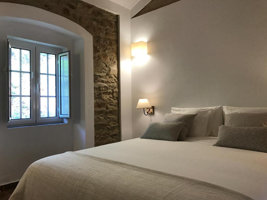 马尔旺Azeite de Marvão, Olivoturismo casa Mestre do Lagar的卧室配有一张大白色床和窗户