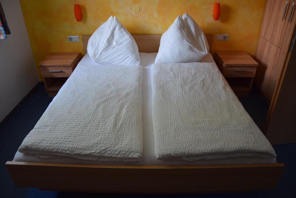 费拉赫Frühstückspension Matheidl的两张带白色床单和枕头的床