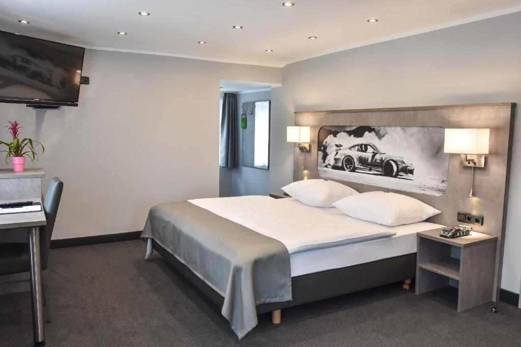 HonerathGT3 Hotel的卧室配有一张大床,墙上挂有汽车照片
