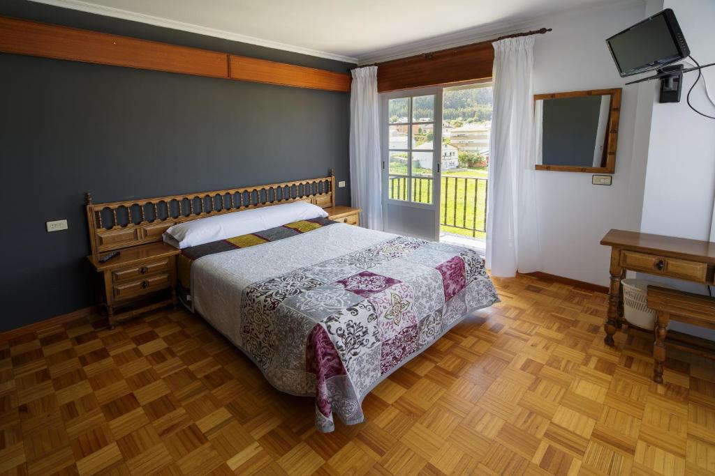 比韦罗阿斯阿雷亚斯二号酒店的一间卧室配有一张床、一台电视和一个窗口