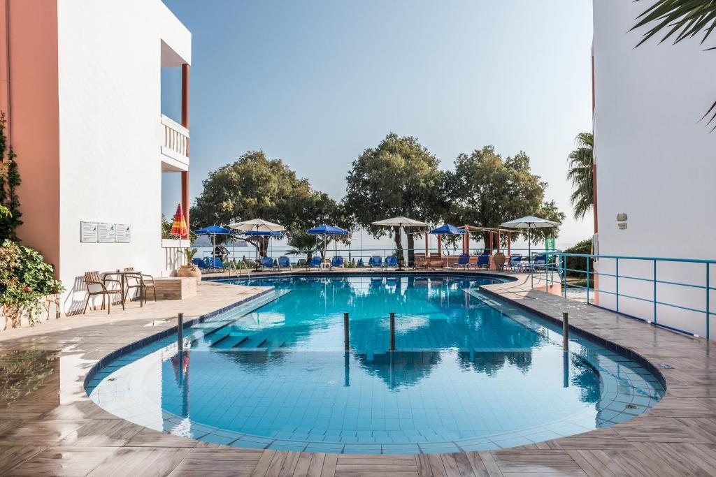 埃亚玛琳娜奈奇多Eden Beach Hotel的度假村的游泳池,配有椅子和遮阳伞
