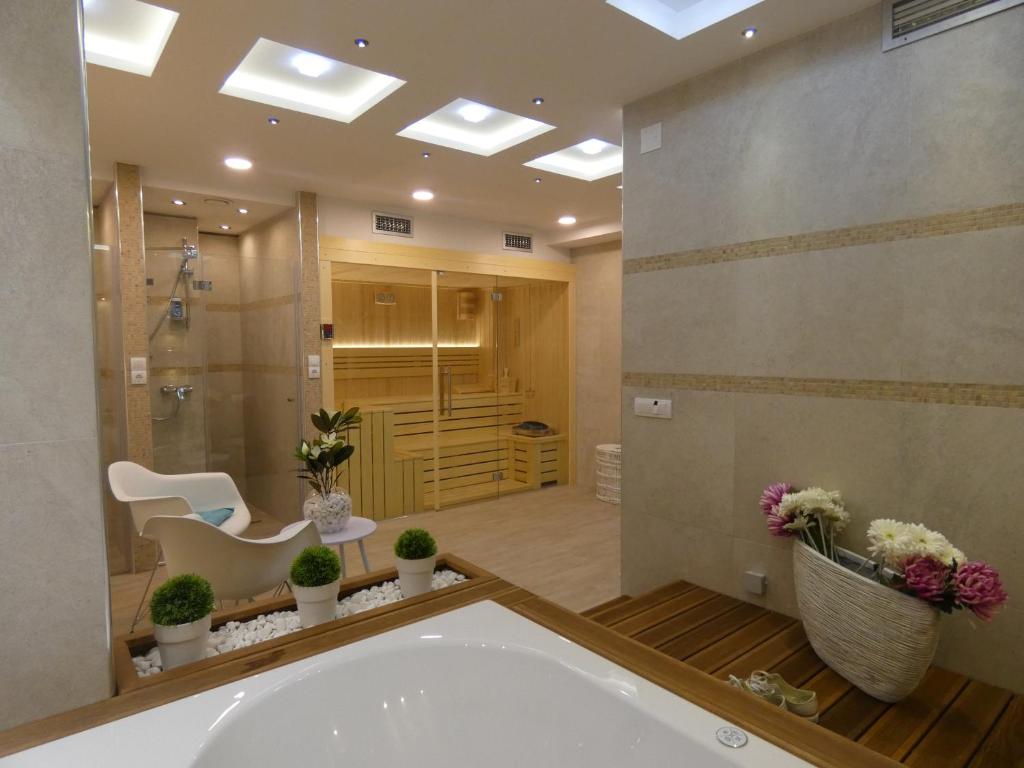 兹拉蒂博尔天然木别墅酒店的带浴缸、淋浴和盥洗盆的浴室