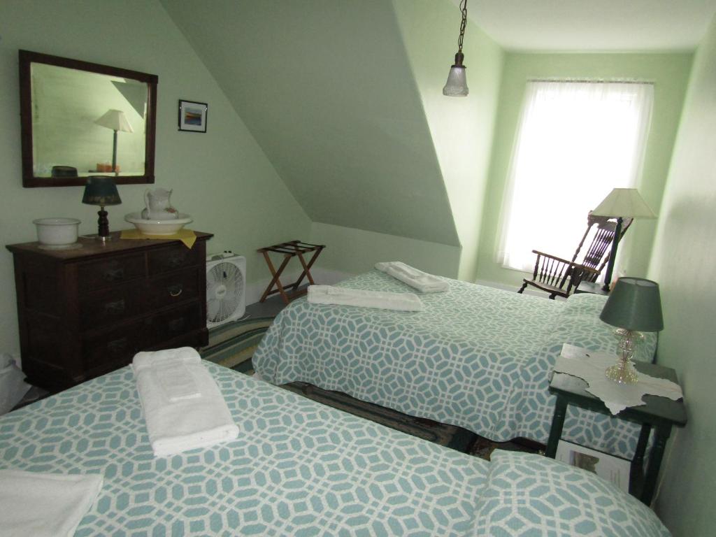 Peaks IslandThe 8th Maine Regiment Lodge and Museum的一间卧室配有两张床和镜子