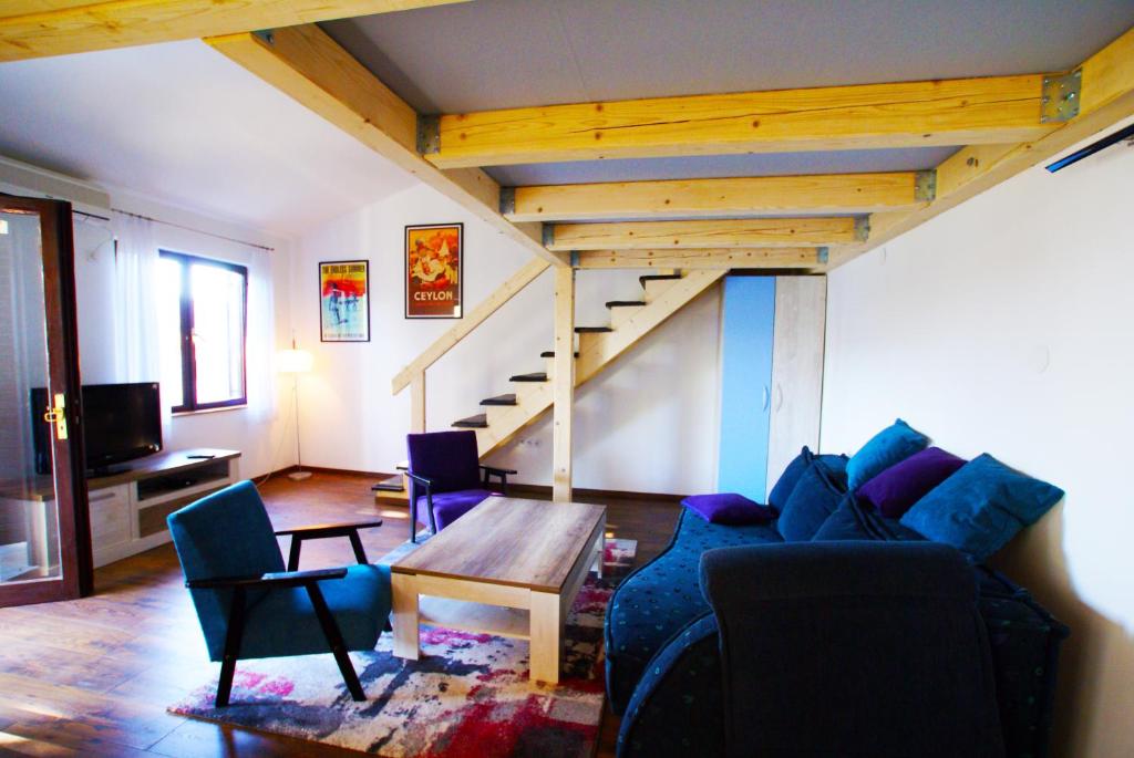 马林斯卡Apartment Olive Groove的带沙发、桌子和楼梯的客厅
