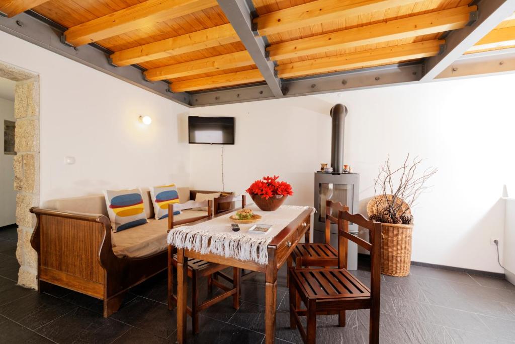 维塞乌Antiga "Casa do Porco"的客厅设有木制天花板和桌椅