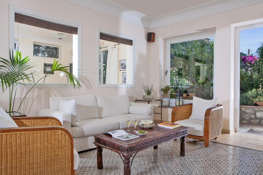 阿纳卡普里塞纳里亚酒店的客厅配有白色家具和桌子