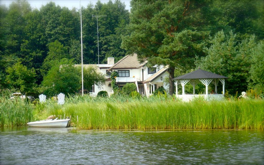 卡斯姆Käsmu Merekalda Apartments - Adults only的水面上房子前面的小船