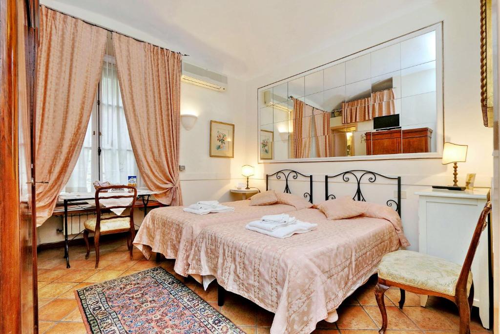 罗马斯皮恩尼套房住宿加早餐旅馆的一间卧室配有一张床、一张桌子和一面镜子