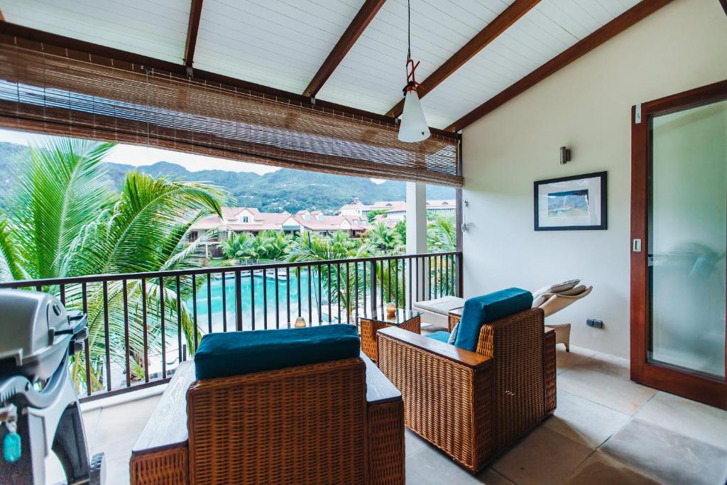 伊甸岛海蓝宝石酒店的阳台配有藤椅,享有海景。