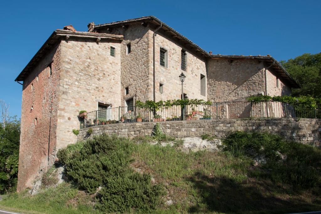 马尔扎博托Tenuta Folesano Wine Estate 13th century的山丘上一座古老的石屋,设有围栏