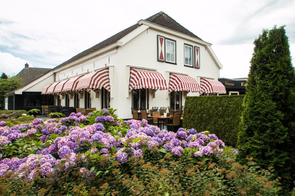 Ees伊泽霍夫餐厅-酒店的白色的建筑,花朵紫色