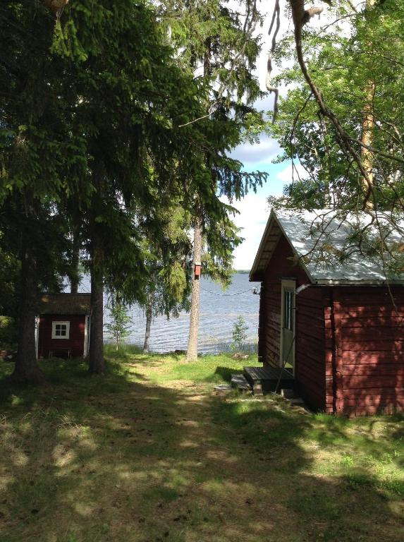 BurträskSvens Stuga的水体旁边的一个小小屋