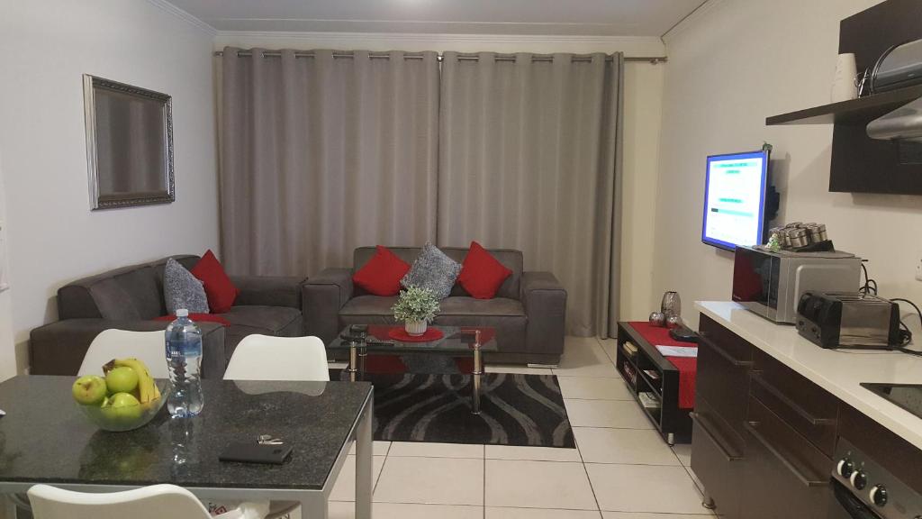 伊登维尔Strelitzia Apartment的客厅配有沙发和桌子