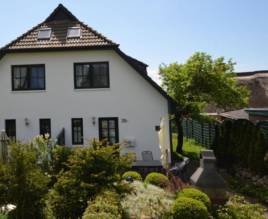 格罗斯齐克Ferienhaus-Seeadler-in-Gross-Zicker-Halbinsel-Moenchgut的前面有花园的白色房子