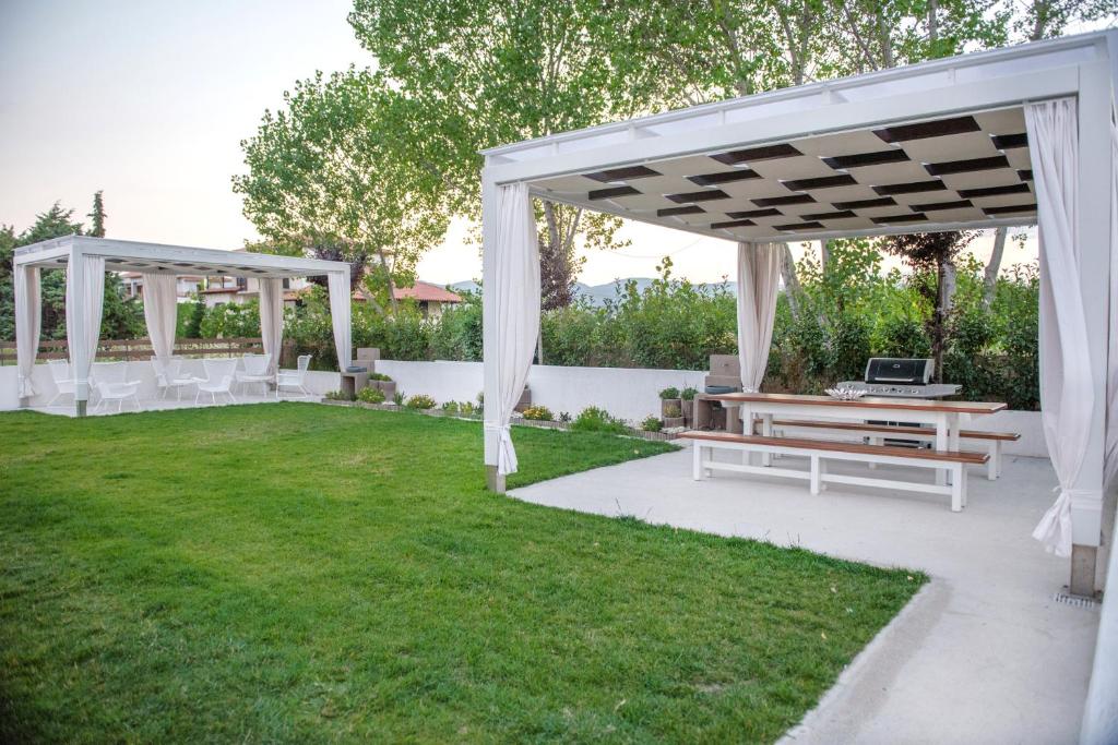 伊里斯斯Corali luxury villas的院子里的白色凉棚和长椅