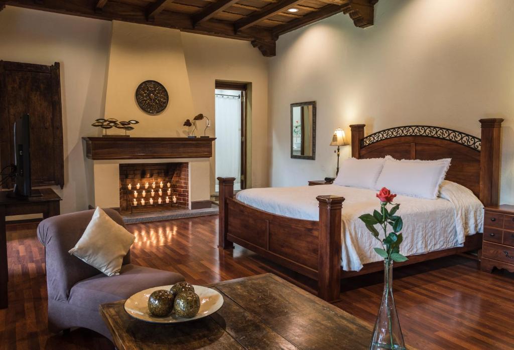 危地马拉安地瓜卡萨圣罗萨精品酒店的一间卧室配有一张床和一个壁炉