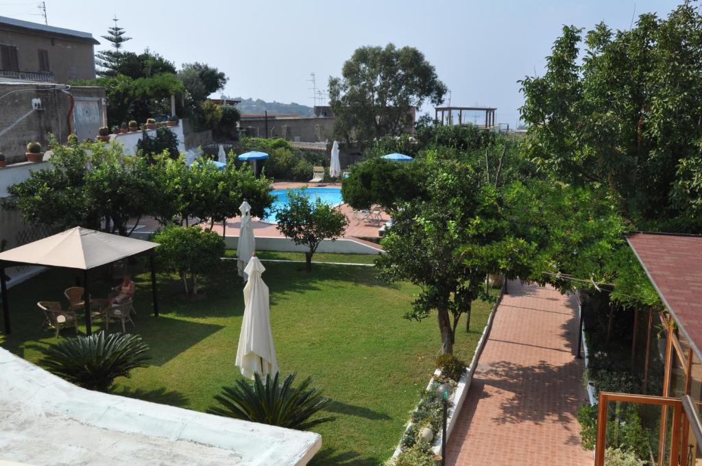 普罗奇达萨沃伊亚酒店的享有带游泳池和遮阳伞的庭院的景色