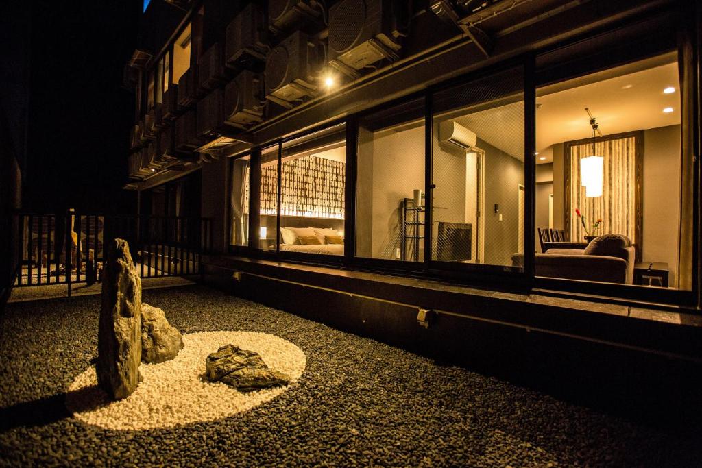京都R&Run Kyoto Serviced Apartment & Suites的一座带窗户和雕像的建筑