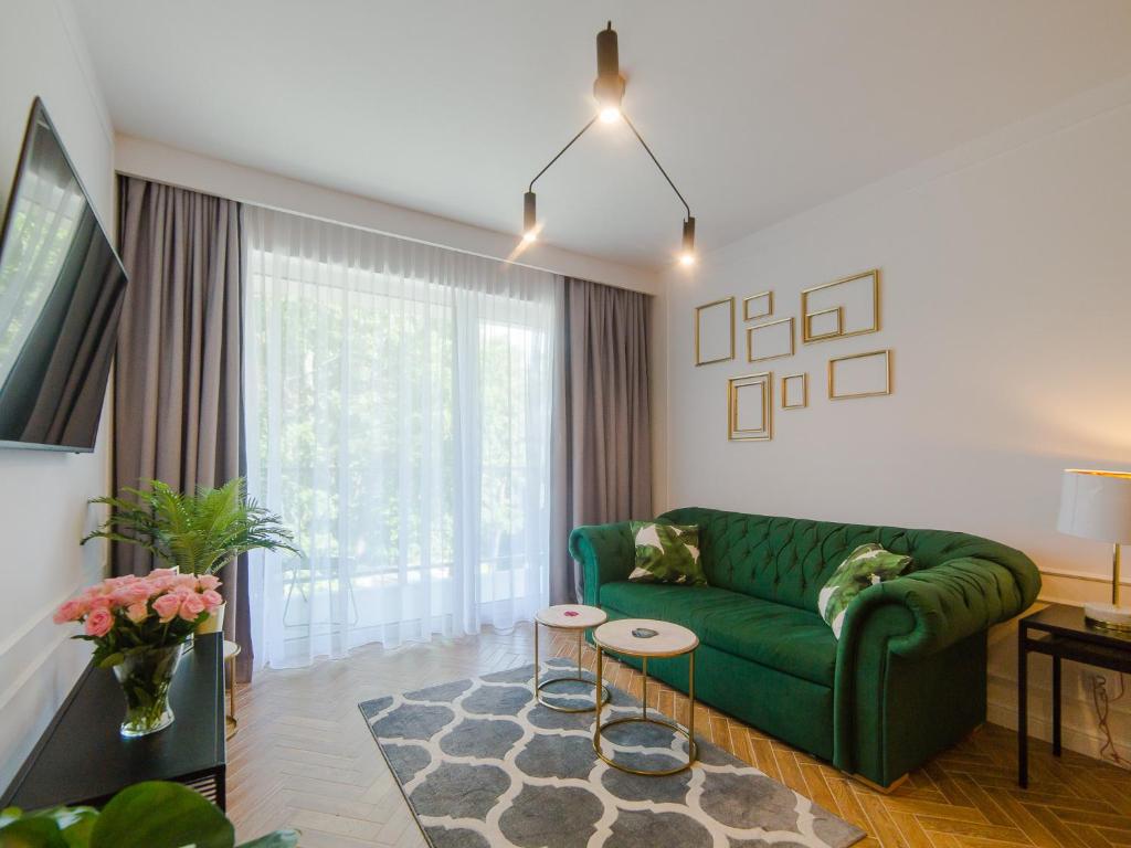 尤斯托尼莫斯基Apartament 59 Dwie Sosny的客厅设有绿色沙发和窗户。