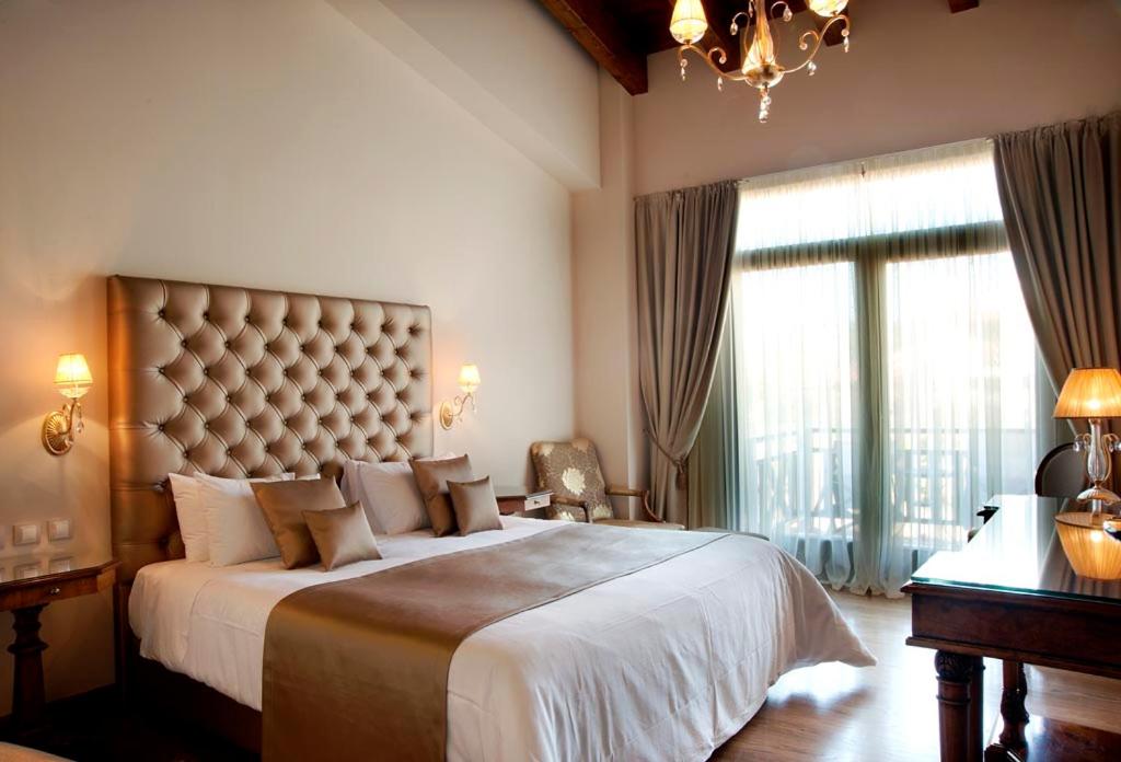 阿拉霍瓦Tagli Resort & Villas的一间卧室设有一张大床和大窗户