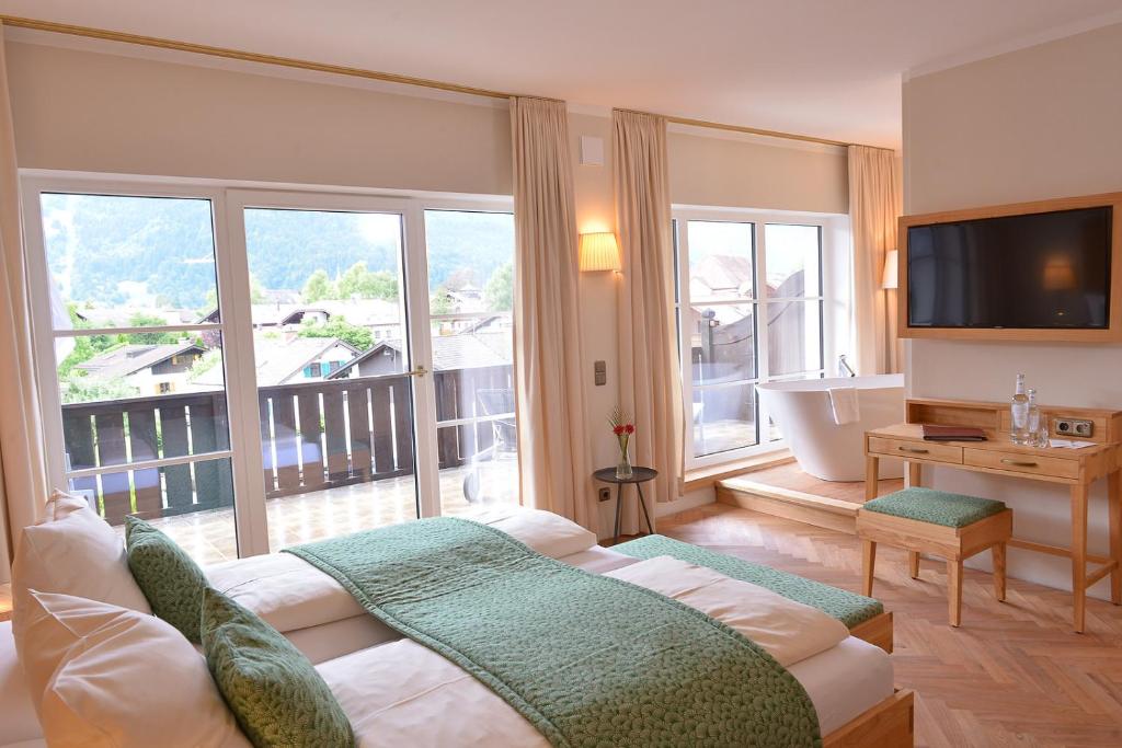 加尔米施-帕滕基兴加米斯切霍夫环保酒店 的带浴缸和大窗户的酒店客房