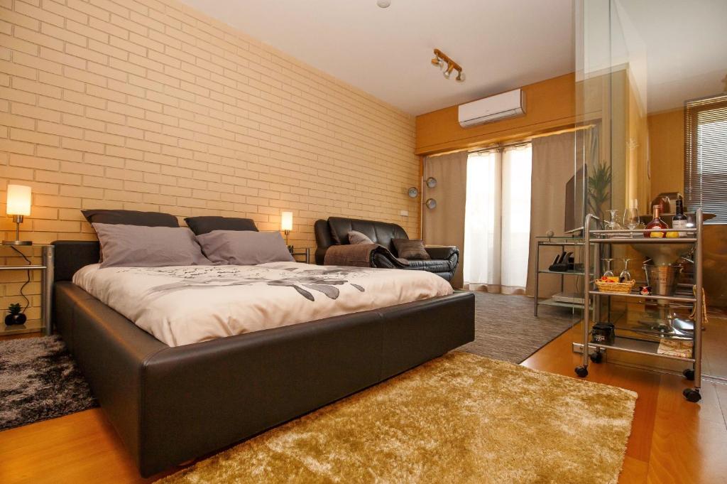 加亚新城Studio Apartment Porto Gaia (Arrabida)的一间卧室配有一张床、一张沙发和一把椅子