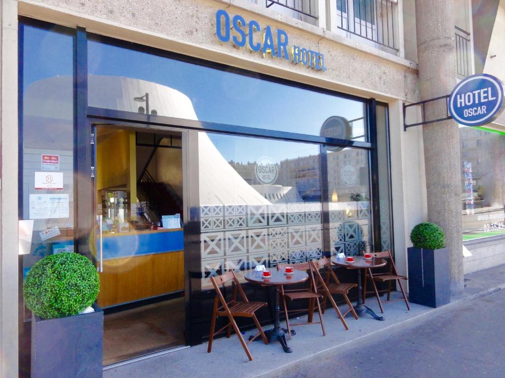 勒阿弗尔Oscar Hôtel Le Havre Centre的窗户上摆放着桌椅的萨萨商店