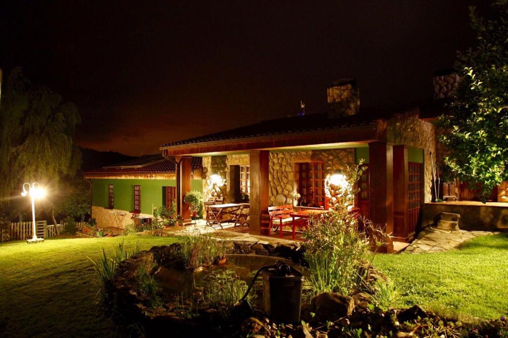 里瓦德塞利亚La Xana Ribadesella的夜晚在院子里有池塘的房子