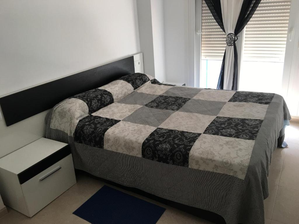 贝尼卡洛Apartamento en Benicarlo的卧室设有黑白床和窗户。