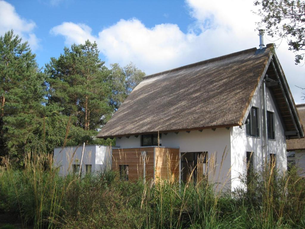 卡尔斯哈根Refugium auf Usedom的一座带茅草屋顶的白色旧房子