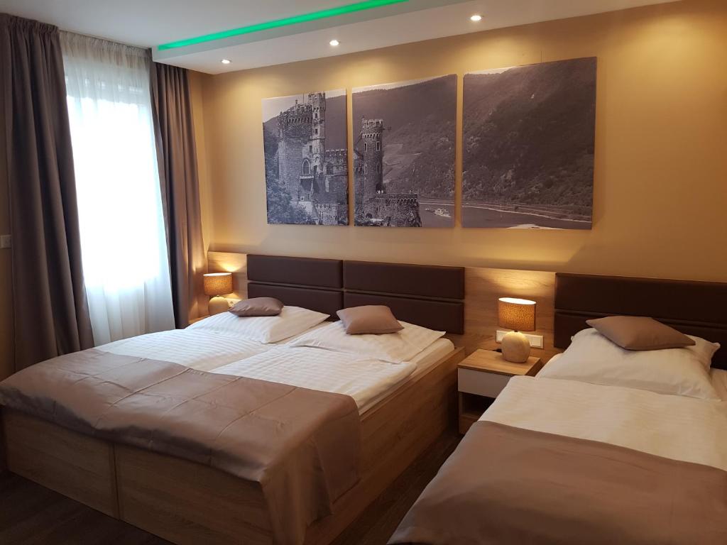 梅尔布施布德瑞酒店的卧室内的两张床,配有两盏灯和一扇窗户