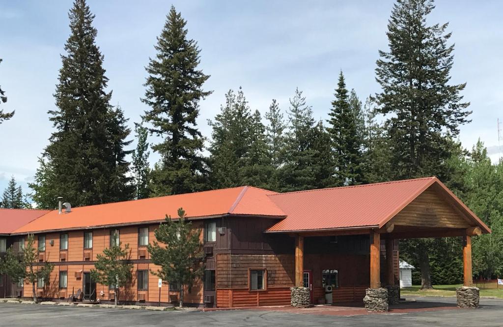 PonderayFairBridge Inn and Suites Sandpoint的一座大型木制建筑,设有红色屋顶