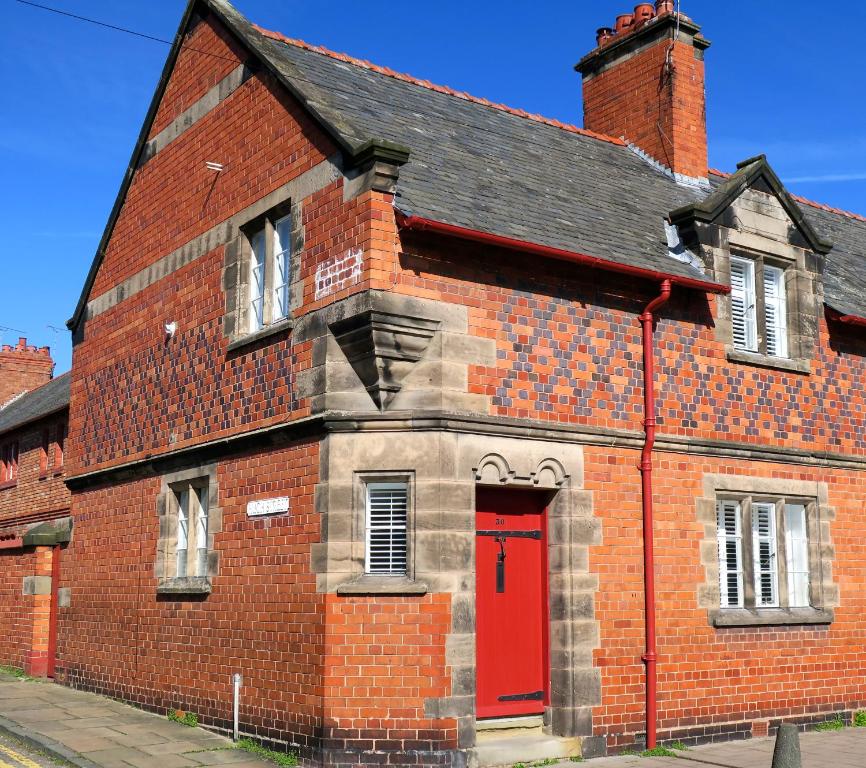 切斯特30 Overleigh Road的一座红色砖砌的旧楼,有红门