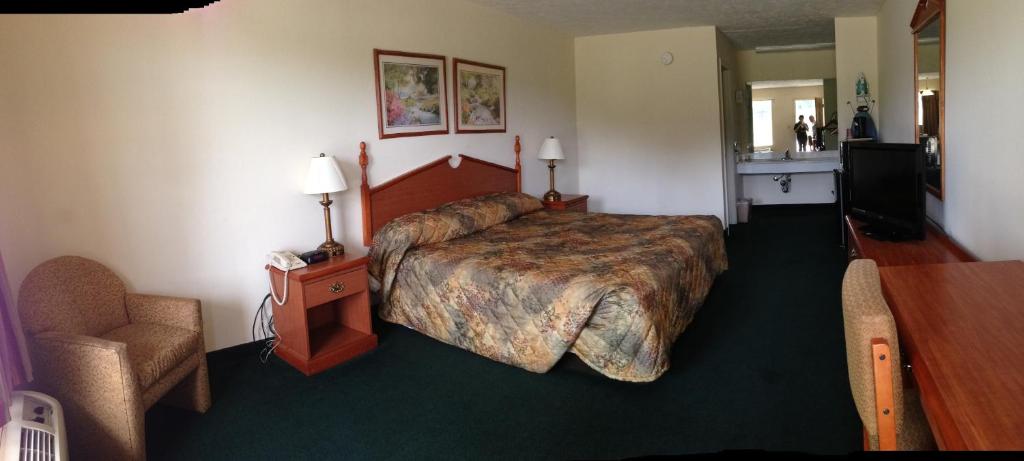 Louisville霍姆盖特酒店的酒店客房带一张大床和一把椅子