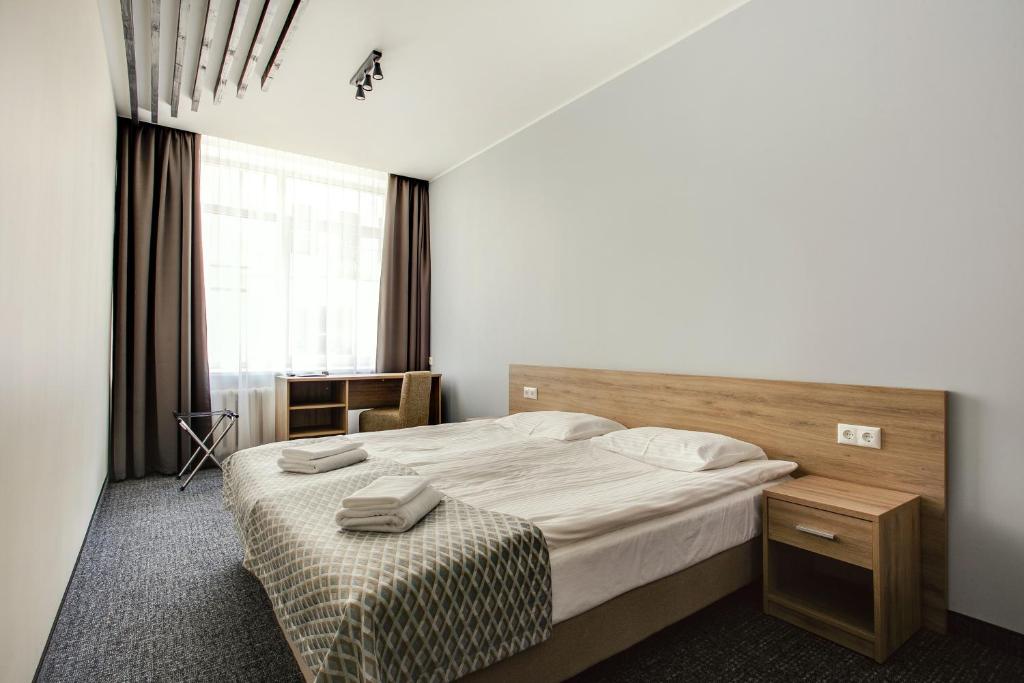 维尔纽斯Old Town Trio Hostel Rooms的一间卧室设有一张大床和一个窗户。