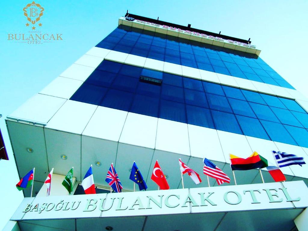 BulancakBasoglu Bulancak Hotel的一座有一大堆旗帜的建筑