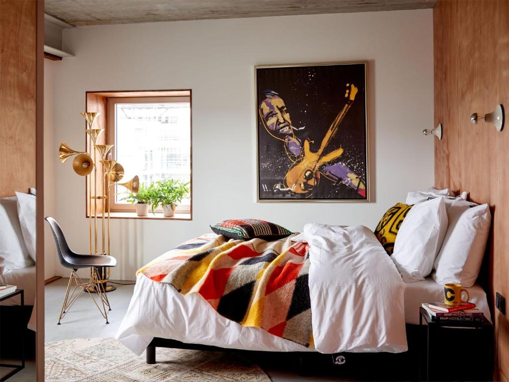 阿姆斯特丹Q工厂酒店 的卧室配有一张壁挂吉他的床
